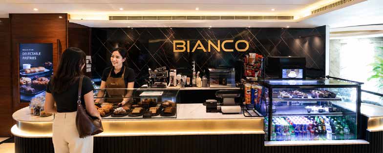 A guest being served at the Bianco counter, pastries displayed under warm light